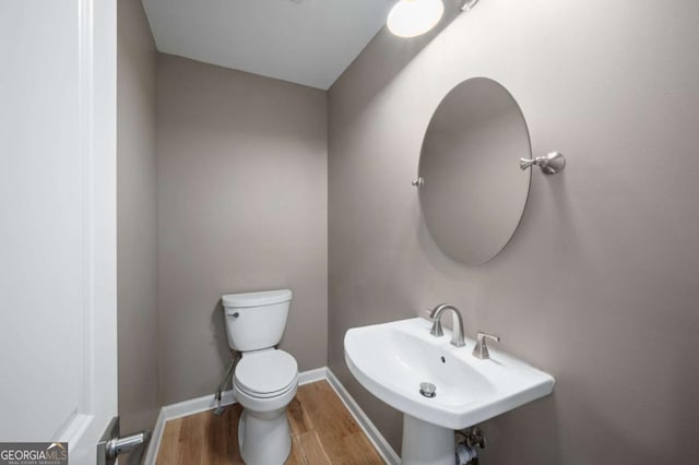 bathroom with sink, hardwood / wood-style floors, and toilet