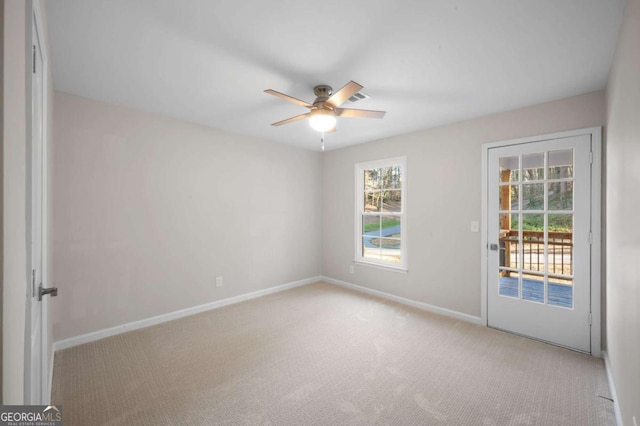 spare room featuring light colored carpet and ceiling fan