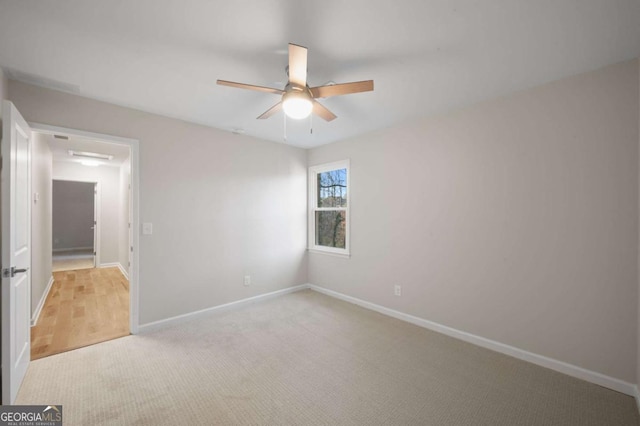 carpeted spare room featuring ceiling fan