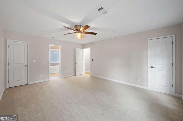 unfurnished bedroom with ensuite bathroom, light carpet, and ceiling fan