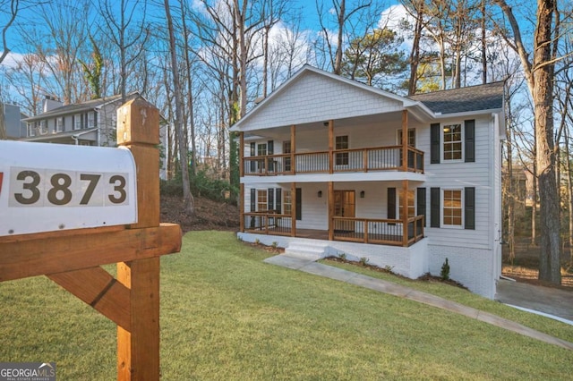 view of front of home with a front lawn, a balcony, and covered porch