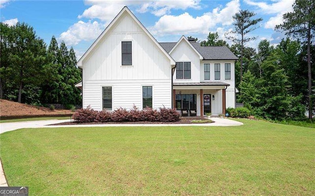 modern inspired farmhouse featuring covered porch and a front lawn