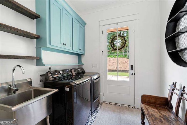 laundry area featuring sink, crown molding, washer and clothes dryer, and cabinets