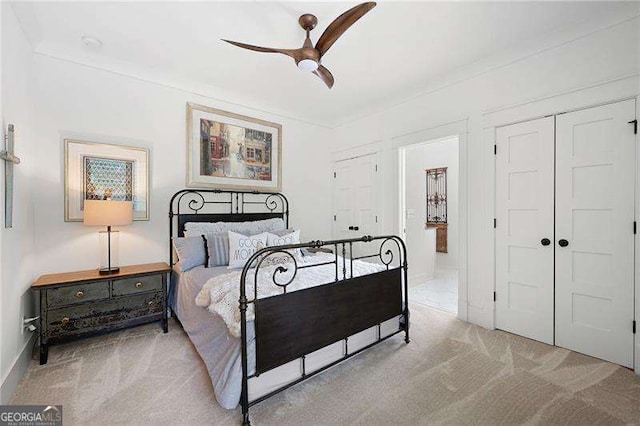 bedroom with ceiling fan, a closet, and light carpet