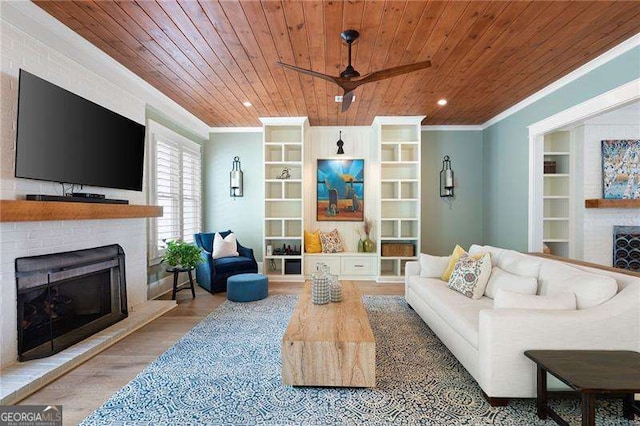 living room with ornamental molding, a brick fireplace, wood ceiling, and built in shelves