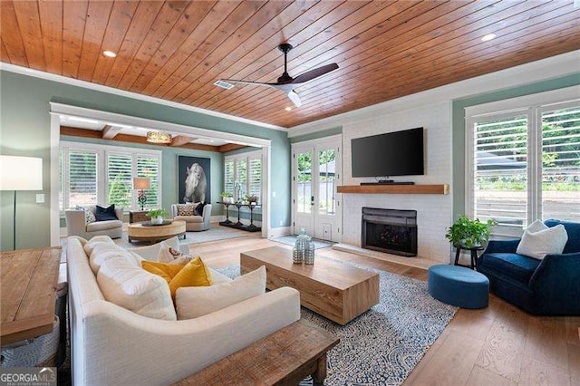 living room with wood ceiling, ornamental molding, and wood-type flooring