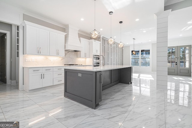 kitchen featuring premium range hood, white cabinetry, and light countertops