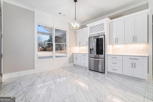 kitchen with light countertops, ornamental molding, visible vents, and stainless steel fridge with ice dispenser