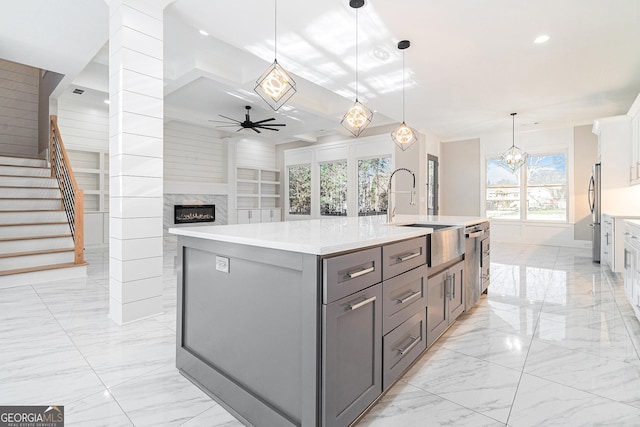 kitchen featuring marble finish floor, gray cabinetry, a ceiling fan, freestanding refrigerator, and a sink