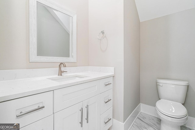 bathroom featuring marble finish floor, vanity, toilet, and baseboards