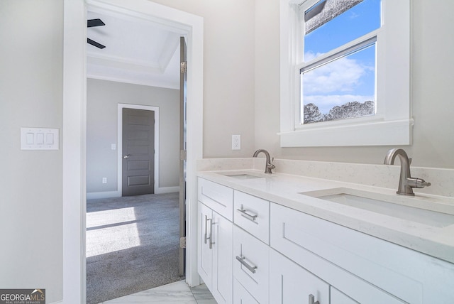 bathroom with ornamental molding, a sink, and baseboards