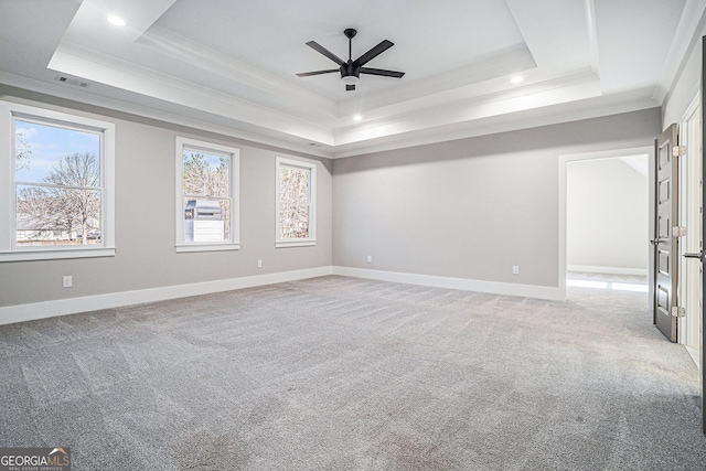 unfurnished room featuring light carpet, baseboards, a tray ceiling, and ornamental molding