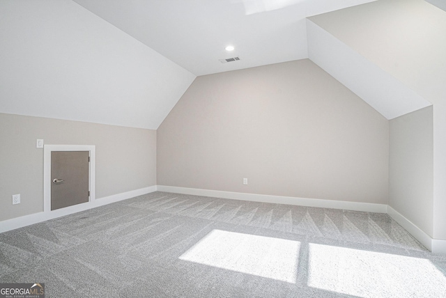 bonus room featuring lofted ceiling, carpet floors, baseboards, and visible vents