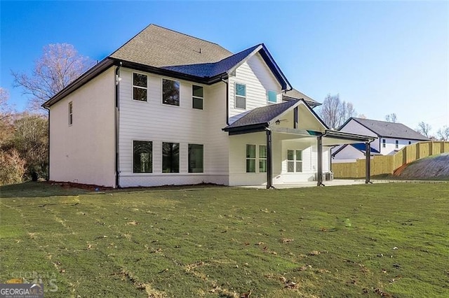 rear view of property featuring a yard and a patio area