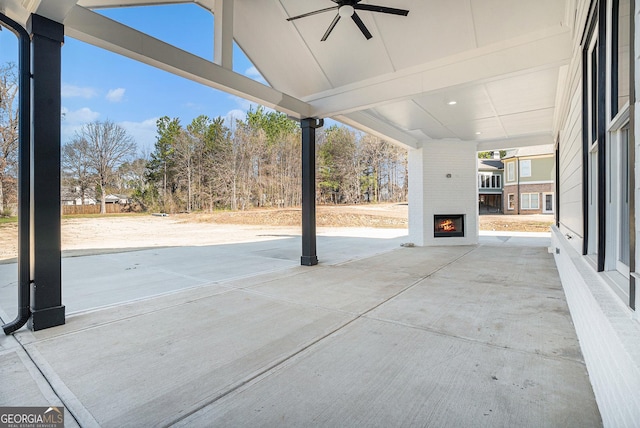 view of patio / terrace featuring a large fireplace and ceiling fan