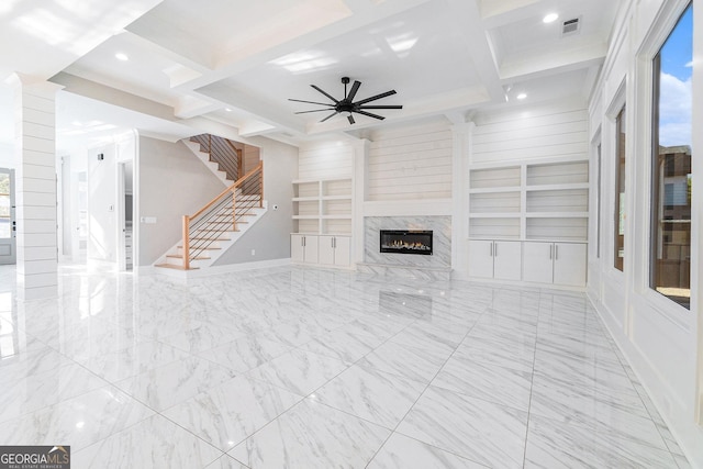 unfurnished living room featuring built in features, visible vents, ceiling fan, coffered ceiling, and stairs