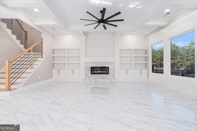 unfurnished living room with marble finish floor, built in features, and beamed ceiling