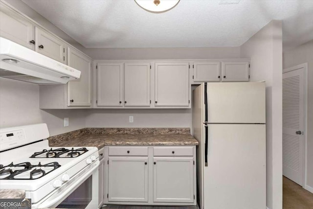 kitchen featuring white appliances, a textured ceiling, and white cabinets