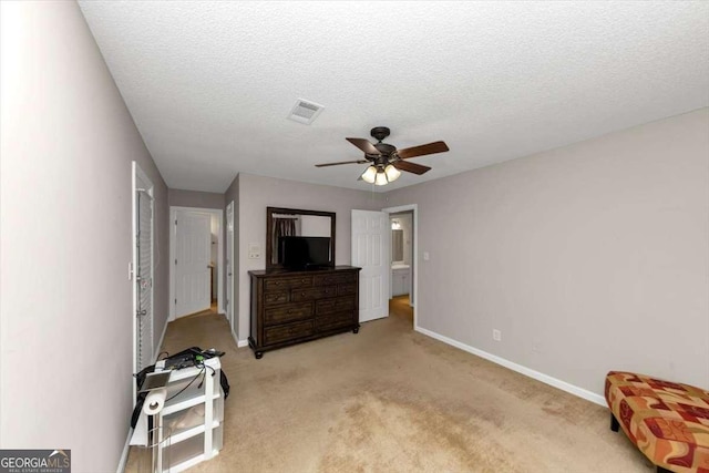 bedroom featuring ceiling fan, light colored carpet, and a textured ceiling