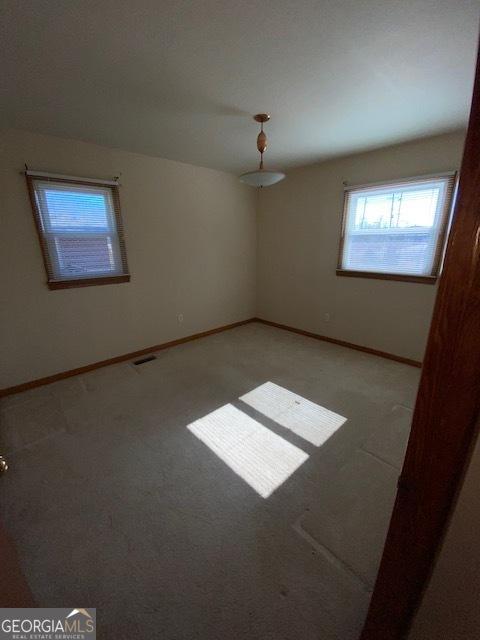 unfurnished room featuring light carpet