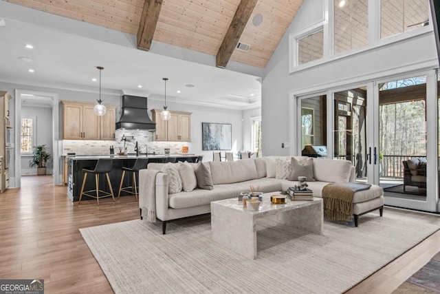 living room featuring high vaulted ceiling, light hardwood / wood-style flooring, wooden ceiling, ornamental molding, and beamed ceiling