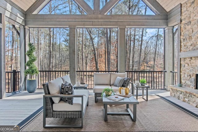 sunroom / solarium with lofted ceiling and an outdoor stone fireplace