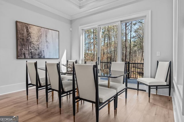 dining space featuring ornamental molding and light hardwood / wood-style floors