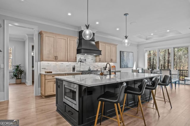 kitchen featuring appliances with stainless steel finishes, a large island, custom exhaust hood, and light brown cabinets