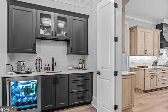 bar featuring tasteful backsplash, sink, wine cooler, light brown cabinets, and light wood-type flooring