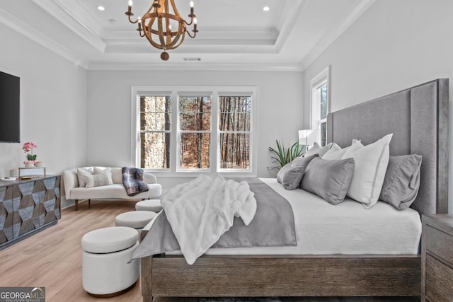 bedroom with a chandelier, ornamental molding, a raised ceiling, and light hardwood / wood-style flooring