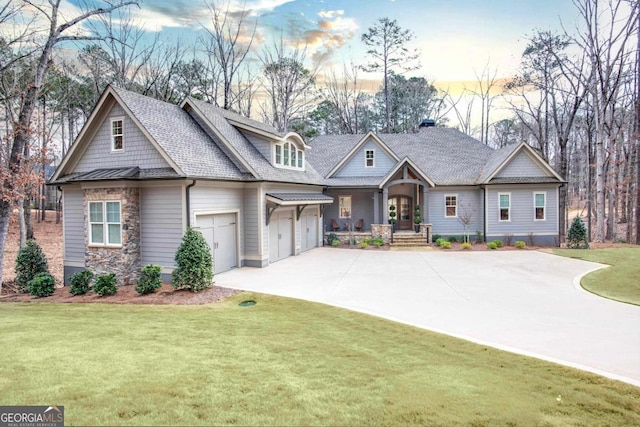 craftsman-style home featuring a garage and a lawn