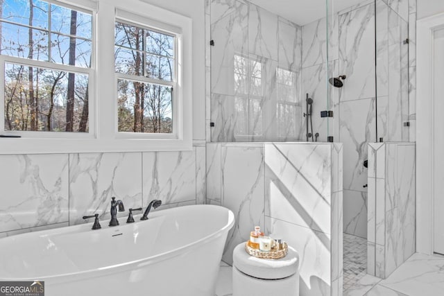 bathroom featuring plenty of natural light and separate shower and tub