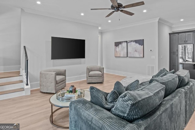 living room with crown molding, ceiling fan, and light hardwood / wood-style flooring