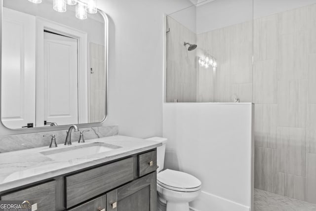 bathroom with vanity, toilet, and a tile shower