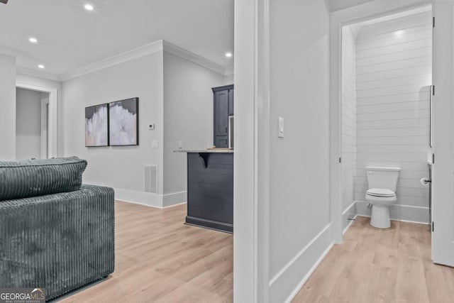 interior space featuring crown molding, toilet, and hardwood / wood-style floors