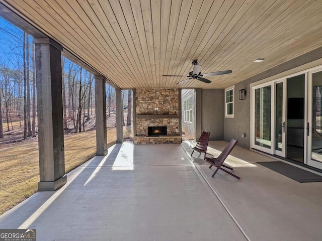 view of patio with ceiling fan and an outdoor stone fireplace