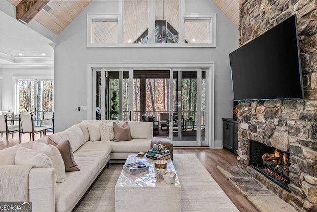 living room featuring a stone fireplace, wood ceiling, high vaulted ceiling, ceiling fan, and hardwood / wood-style floors