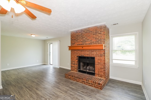 unfurnished living room with ceiling fan, a fireplace, dark hardwood / wood-style flooring, and a textured ceiling