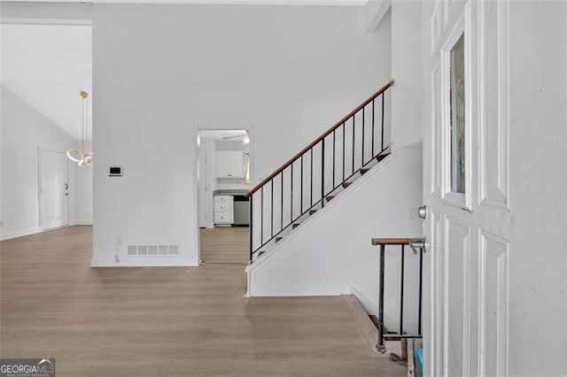 foyer with high vaulted ceiling, ceiling fan, and light hardwood / wood-style flooring