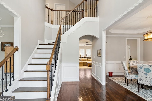 entrance foyer with dark wood-type flooring, ceiling fan, and ornamental molding