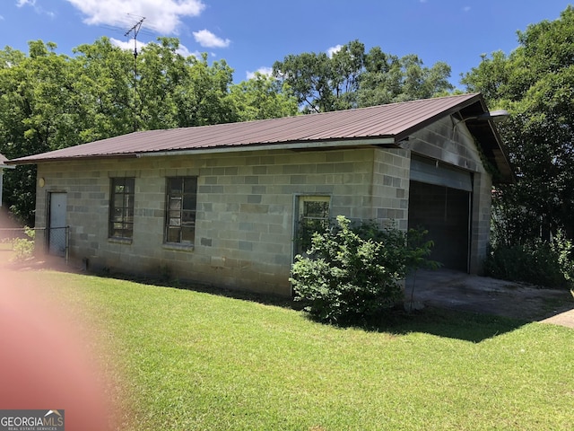 view of home's exterior with a garage and a lawn