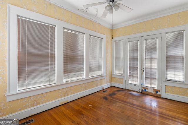 unfurnished sunroom featuring plenty of natural light, a baseboard heating unit, and ceiling fan