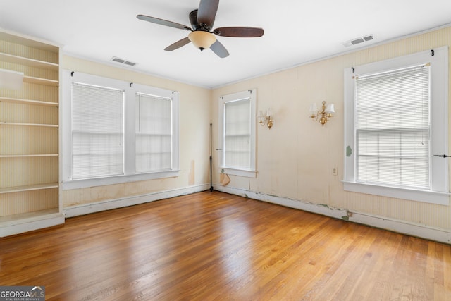 spare room with hardwood / wood-style flooring, ceiling fan, and a baseboard heating unit