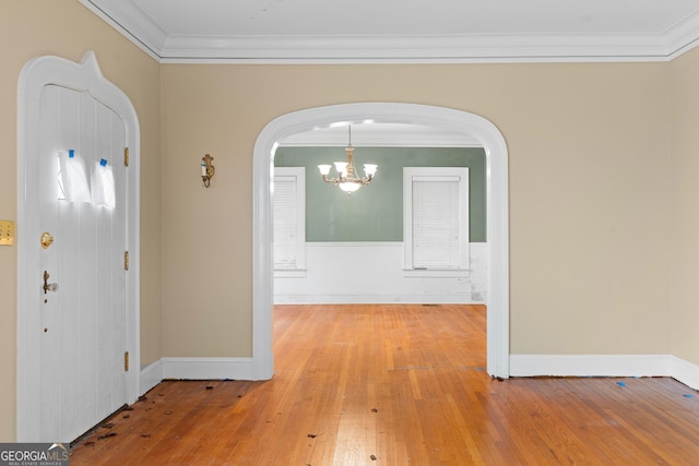 entryway featuring an inviting chandelier, hardwood / wood-style flooring, and ornamental molding