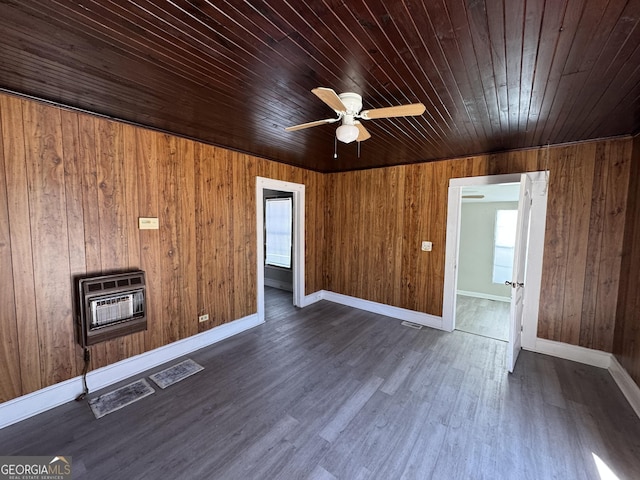 interior space with dark wood-style flooring, heating unit, a ceiling fan, wood ceiling, and baseboards