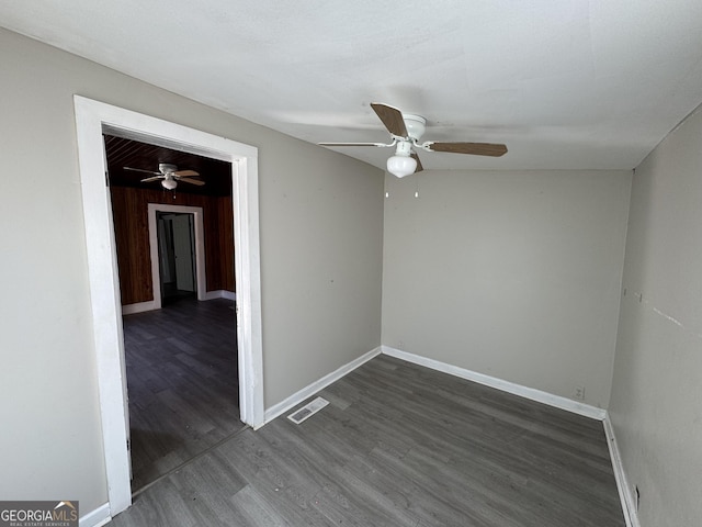 unfurnished room featuring baseboards, visible vents, and dark wood-type flooring