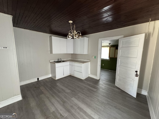 kitchen with a notable chandelier, a sink, white cabinetry, dark wood-style floors, and pendant lighting