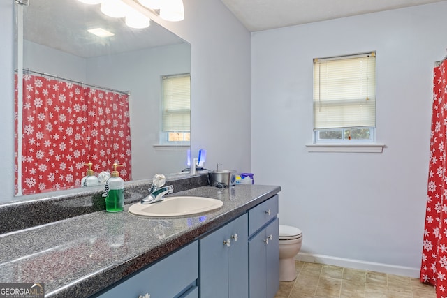 bathroom with a healthy amount of sunlight, toilet, and vanity