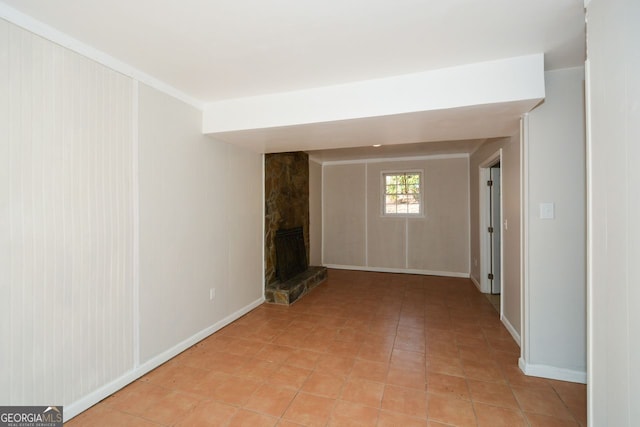 unfurnished room featuring a fireplace and light tile patterned floors