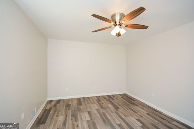 unfurnished room featuring dark wood-type flooring and ceiling fan